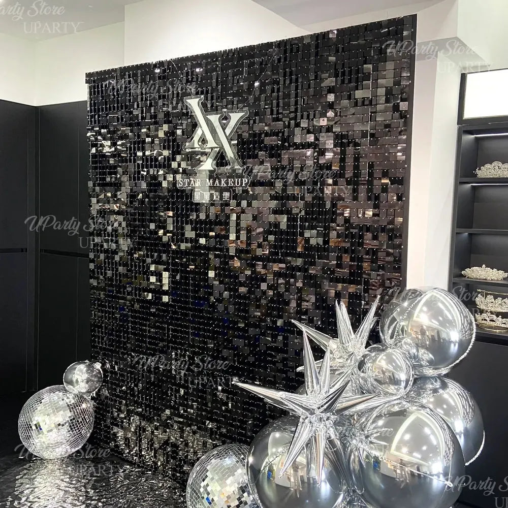 Fond mural pailleté sombre avec un grand logo stylisé X pour une fête ou un événement.