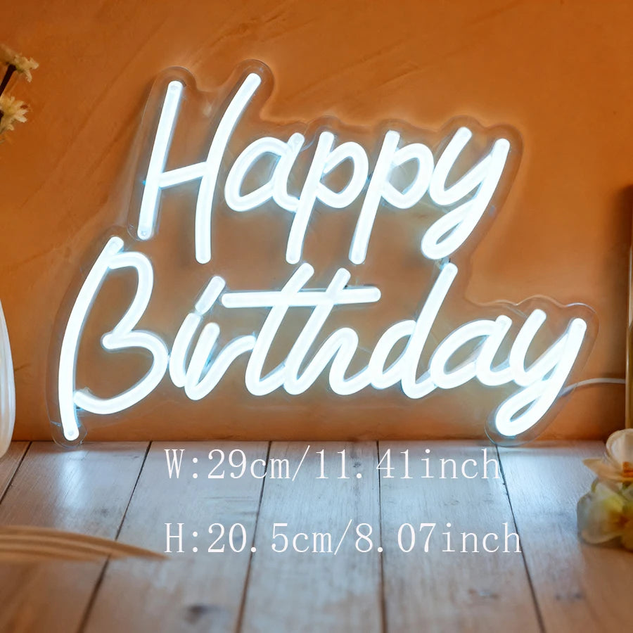 A glowing neon wall sign spelling out Happy Birthday on an orange wall.