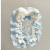 Porte-cartes en dentelle bleu clair et blanc, décorée de nœuds moelleux blancs et d'un charm de croix bleue
