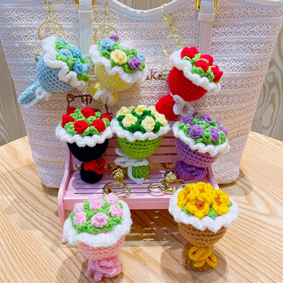 A display of handmade crochet flower bouquets in various colors and textures, arranged on a pink wooden stand.