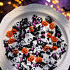 A variety pack of 50 black and white Halloween resin nail charms, including bats, ghosts, and pumpkins, displayed on a white 