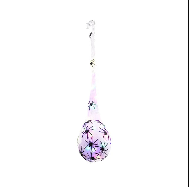 A long, translucent decoration shaped like a spider with glowing light-up eggs.