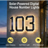 Primer plano de un letrero numérico digital solar que muestra el número 103 montado en una pared exterior.