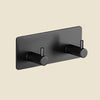 A matte black extra thick self-adhesive wall hook for keys and jewelry mounted on a wall.