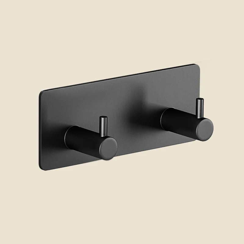 A matte black extra thick self-adhesive wall hook for keys and jewelry mounted on a wall.