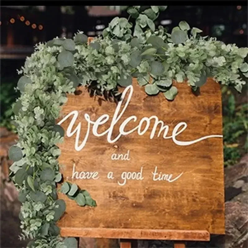 A welcome sign decorated with artificial eucalyptus leaf garland for home decor.