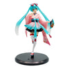 A PVC collectible figurine of Hatsune Miku in a pink and teal outfit with long blue hair.