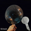 A hand is holding a large, transparent inflatable balloon against a black background.