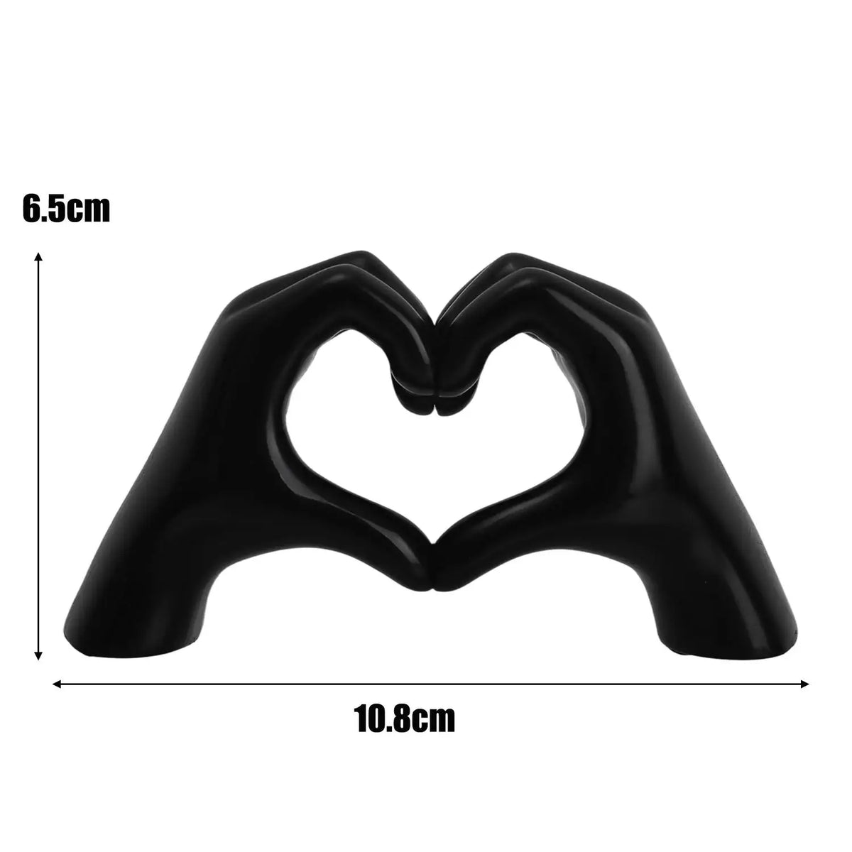 Black heart shape sculpture formed by two hands, measuring 6.5cm high and 10.8cm wide.
