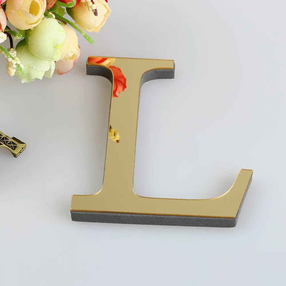 A gold letter L wall decal is shown next to a bouquet of light yellow and cream flowers.