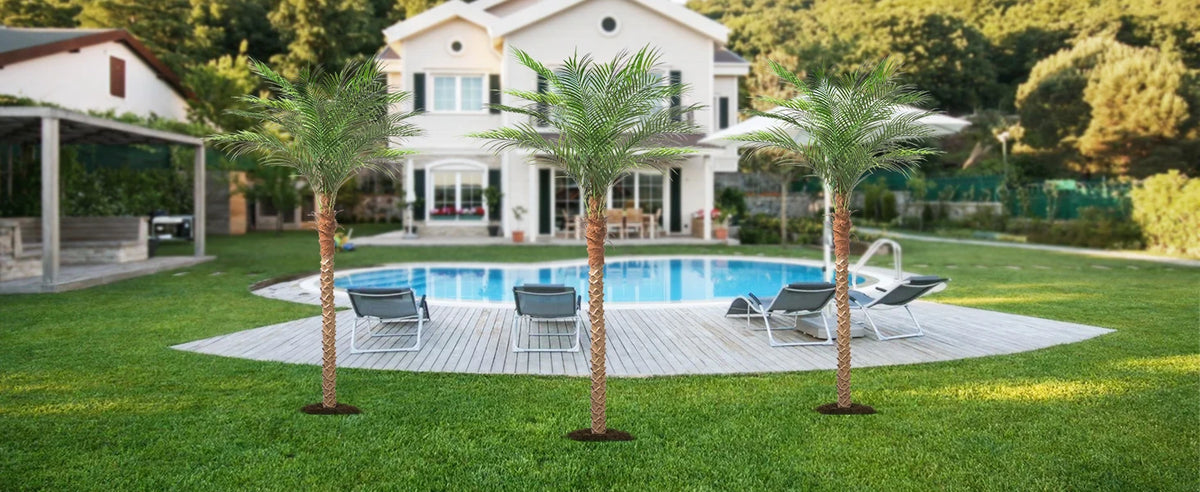 Artificial golden palm trees planted in a lawn near a modern house and swimming pool.