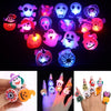 A collection of glow-in-the-dark Halloween rings with flashing lights displayed on a dark background.