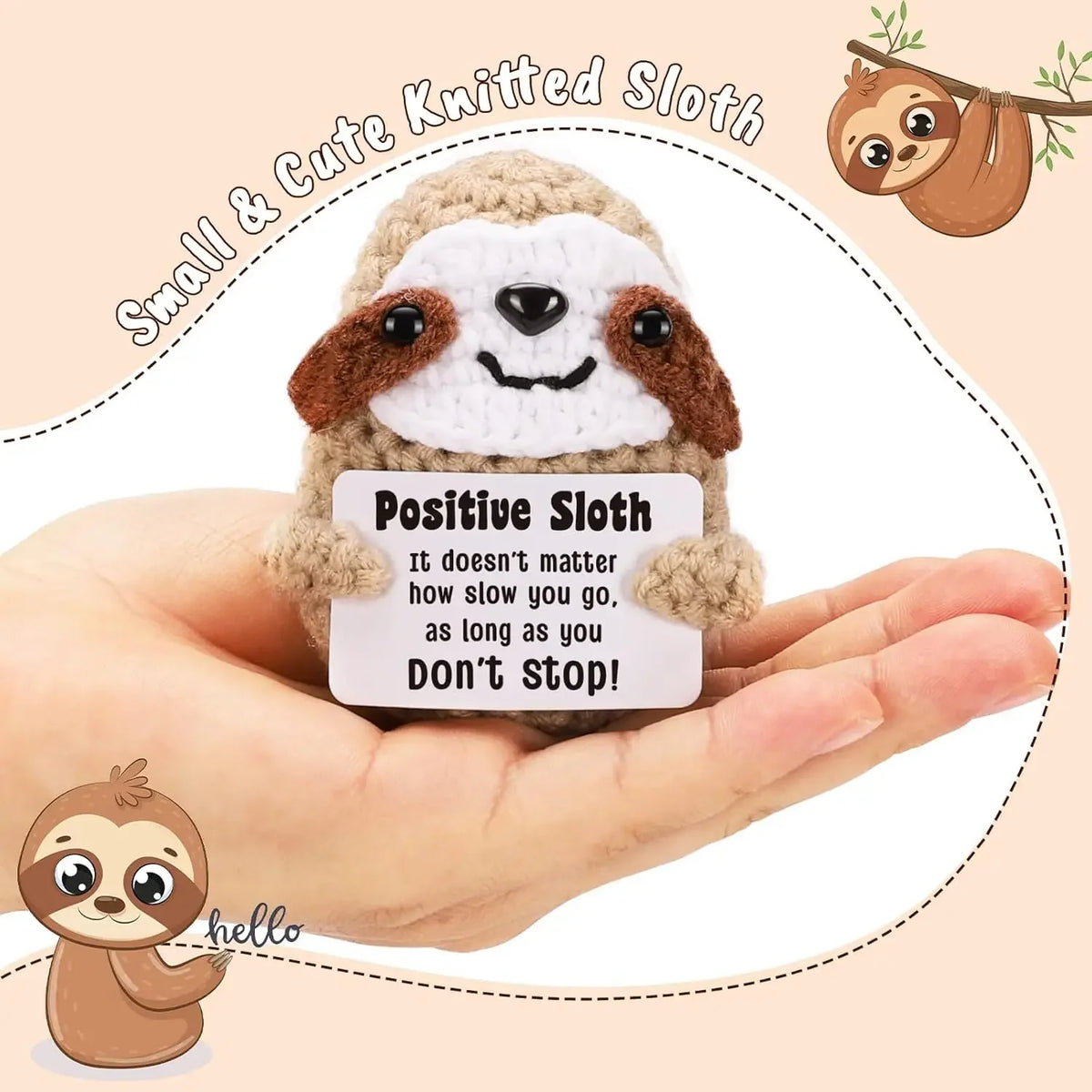 A handmade crochet sloth doll with a positive message card is held in a person's hand.