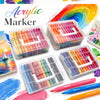 A collection of acrylic marker pens in various colors and shades arranged in plastic storage boxes and scattered on a white b