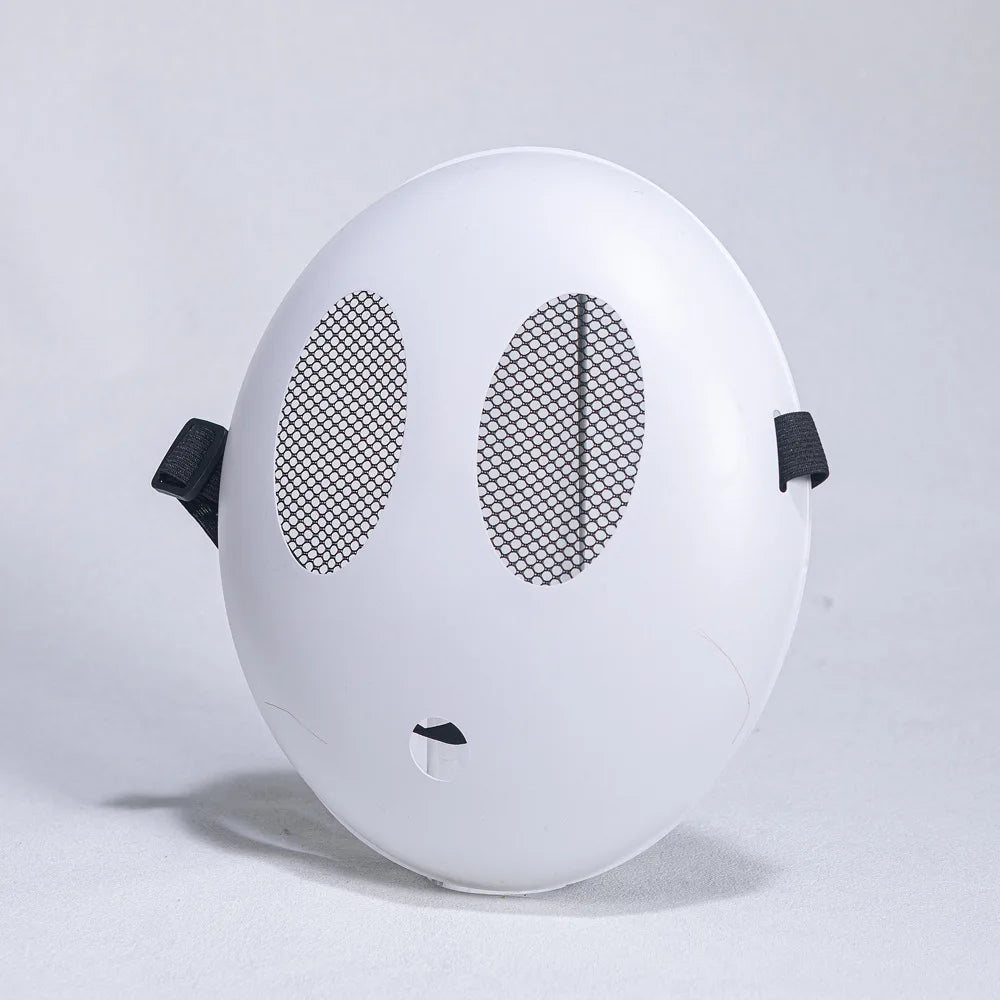 A white, spherical mask resembling a shy guy face with large eye cutouts and a small mouth, displayed against a light backgro