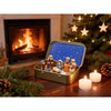 Miniature nativity scene set featuring Mary, Jesus, shepherd, and animal figurines displayed in an open gold-colored box.