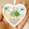 A heart-shaped acrylic pendant featuring sea glass elements and a palm tree design, held in a hand.