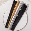 A set of elegant wooden hand fans with black and white designs displayed on a white surface.