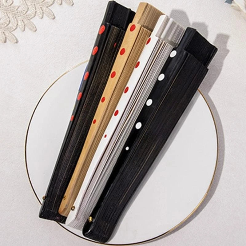 A set of elegant wooden hand fans with black and white designs displayed on a white surface.