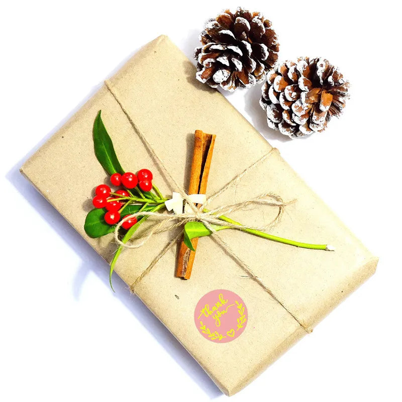 A kraft paper gift box tied with twine, decorated with red berries and pine cones.