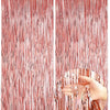 Two panels of metallic rose gold foil fringe curtains hanging vertically.