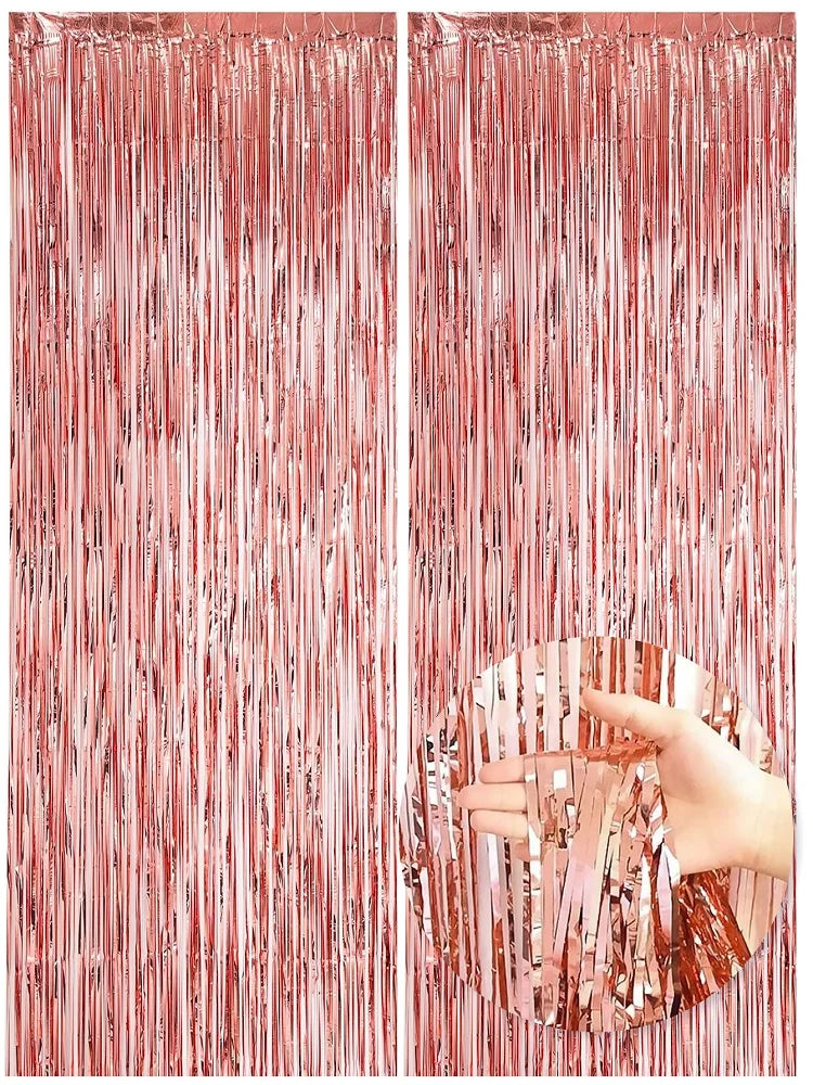 Two panels of metallic rose gold foil fringe curtains hanging vertically.