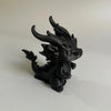A black 3D printed mini dragon statue collectible with horns and detailed texture.