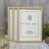 A set of three light wood photo frames with white mats and a framed piece of art featuring a stylized tree design.