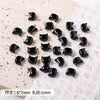 A collection of small black cat head glass beads for jewelry making, displayed on a white surface.