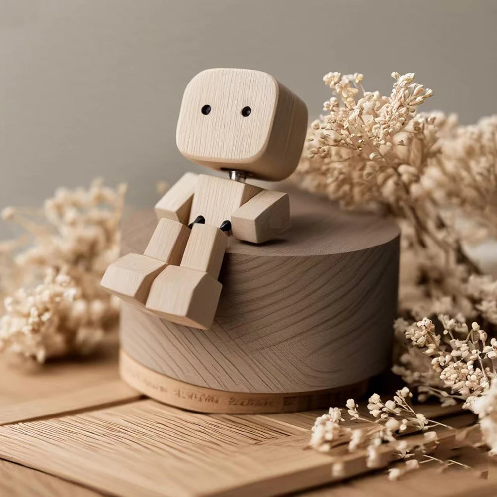 Figurine en bois artisanal à secouer décorative sur une surface en bois clair entourée de branches de fleurs séchées.