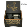 A wooden box containing a music melody box with a gold-colored anime character design.