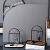 A gray leather key holder featuring wrought iron racks for organizing keys and small items on a desk.