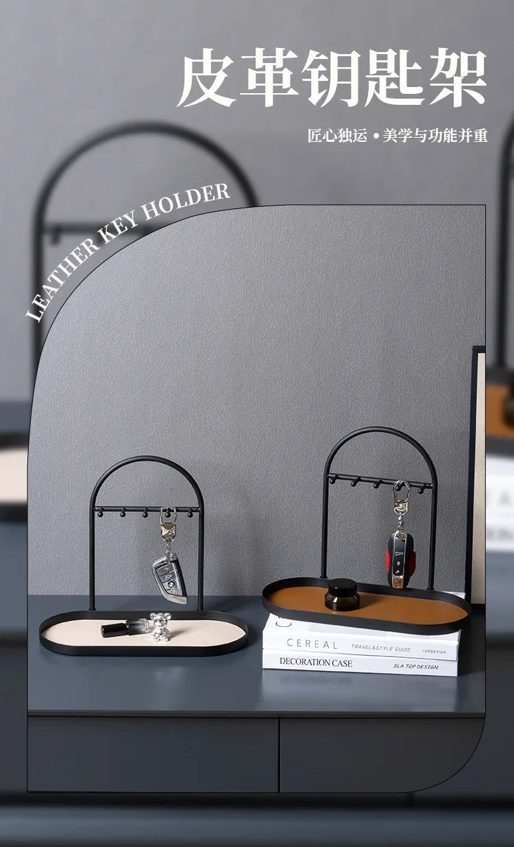 A gray leather key holder featuring wrought iron racks for organizing keys and small items on a desk.