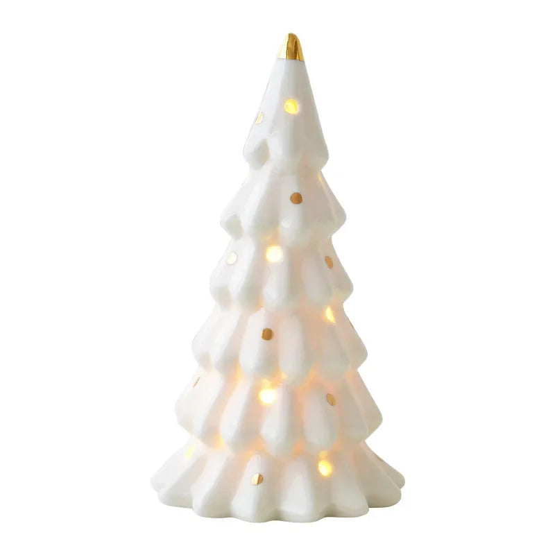 A white ceramic glow-in-the-dark mini Christmas tree decor with a gold topper.