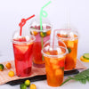 A set of disposable plastic cups with lids filled with various colored cold drinks like juice and iced tea.