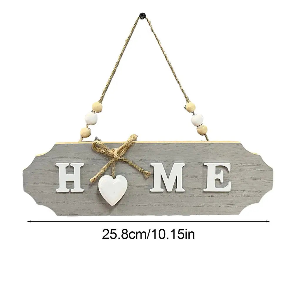 A wooden welcome sign with the word HOME carved into it, featuring a heart cutout and suspended by twine.