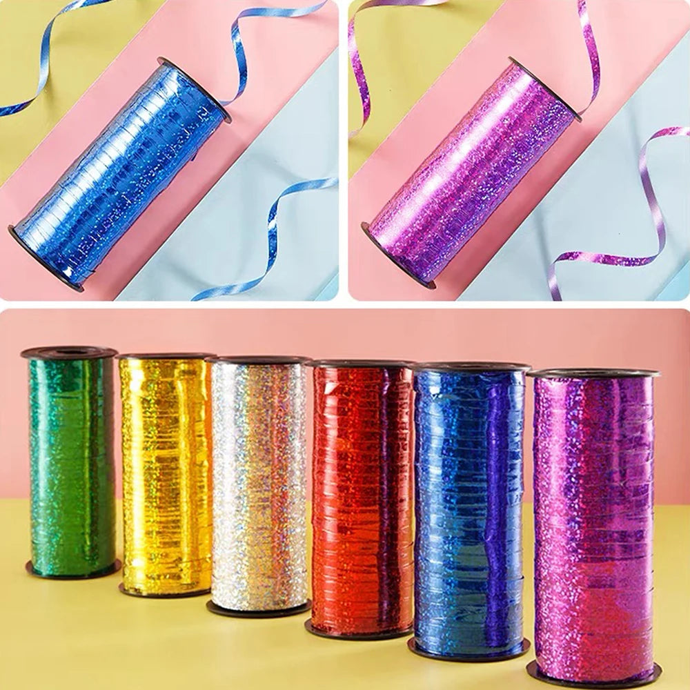 A collection of glitter curling ribbon rolls in various colors including blue, purple, green, gold, and red.
