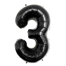 A large black foil number balloon shaped like the number three.