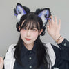 A young woman with long black hair is wearing a furry fox ears headband and a black shirt.