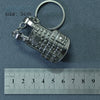 Silver alloy gun model miniature keyring with a circular loop and a ruler for scale.