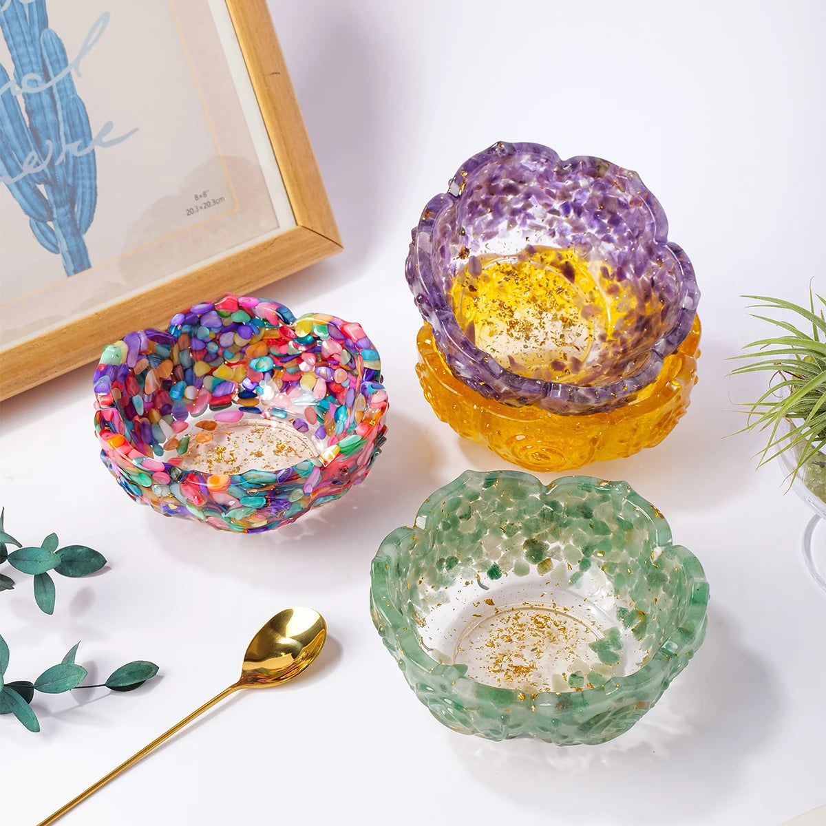 A collection of natural crystal lotus bowls in purple, yellow, and green colors displayed on a white surface.