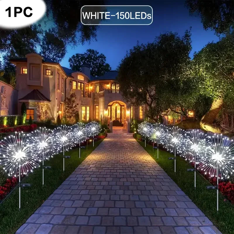 A row of white LED fireworks lights illuminates a stone pathway in a garden setting.