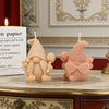 A pink silicone candle mold shaped like a gnome with a honeycomb hat sitting on a decorative table.