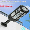 A black solar street light head with 240° lighting mounted on a white building exterior.