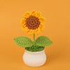 Handmade knitted sunflower with yellow petals and brown center growing in a white pot