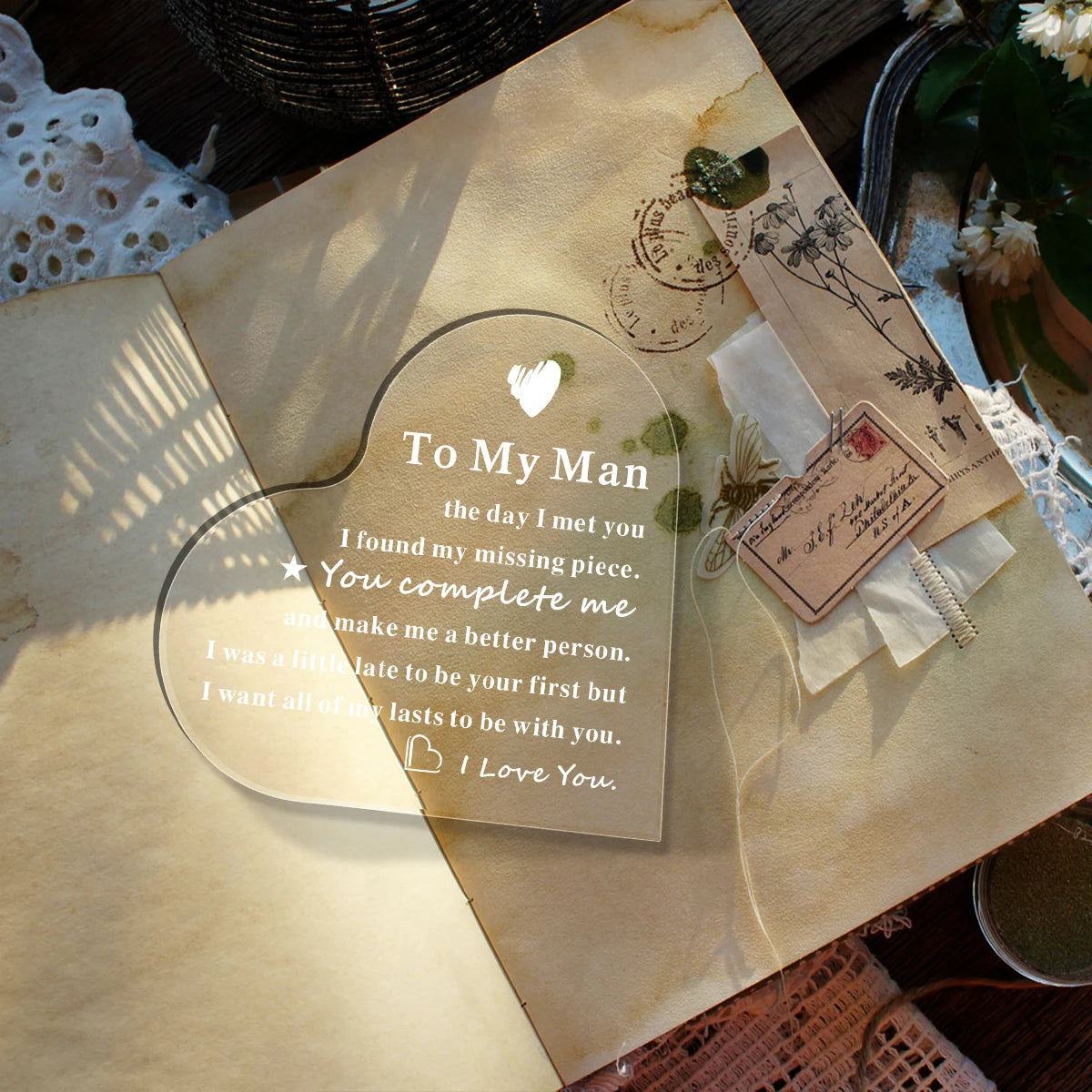 A handmade acrylic heart keepsake plaque with a message to the man and a heart symbol on parchment paper.