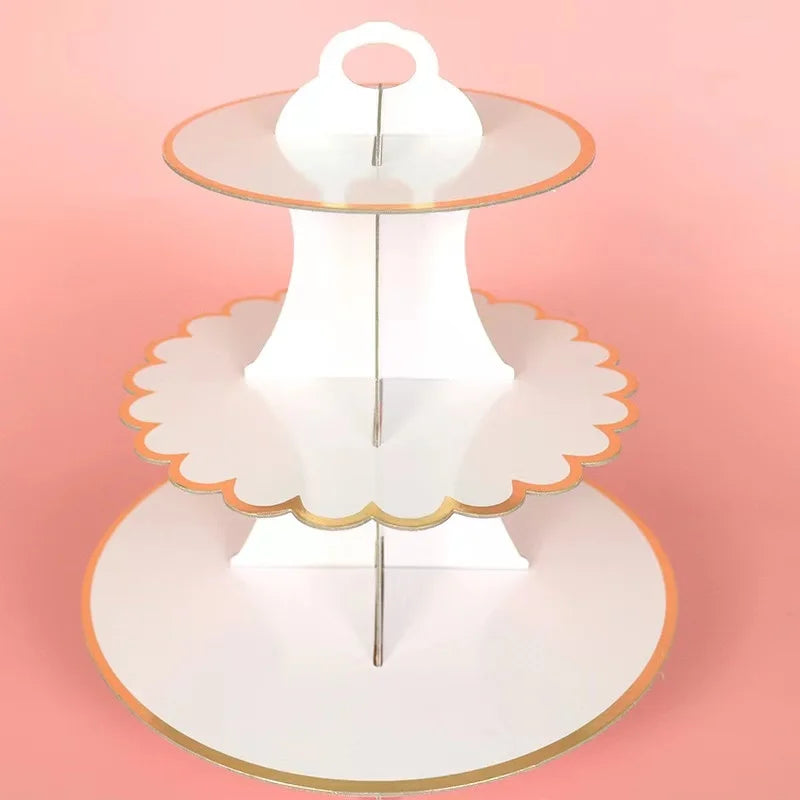A three-tier rainbow cupcake stand with white and gold accents for dessert tables.
