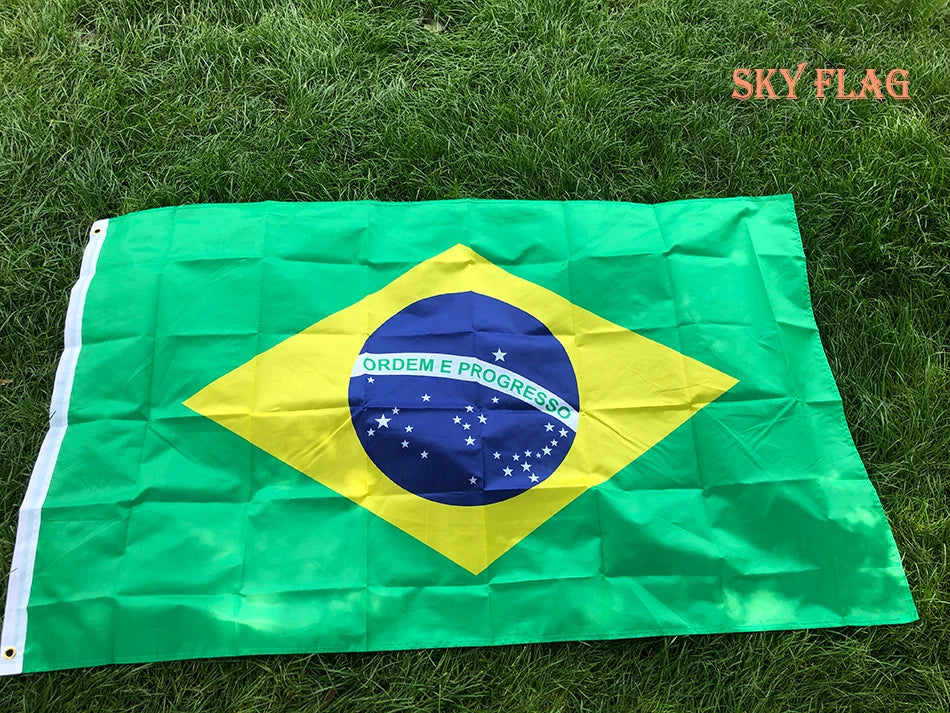 A large green Brazil flag is displayed on green grass.