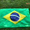 A large green flag of Brazil with a yellow diamond and blue circle featuring the text ORDEM E PROGRESSO displayed on green gr
