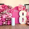 A vibrant pink and rose gold balloon garland featuring various sized balloons and large number balloons for a celebration.